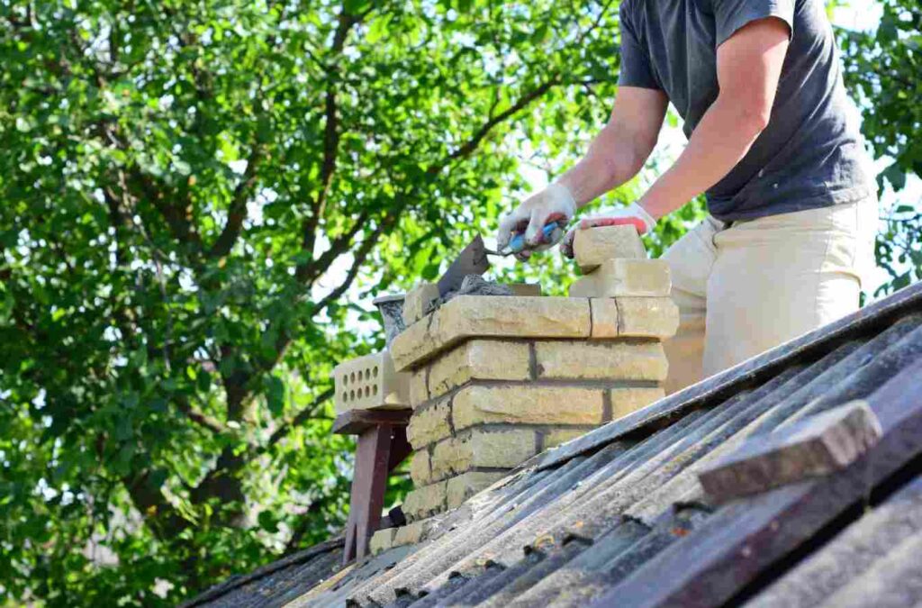 Roofing contractor repairing chimney flashing on residential roof in Kildare